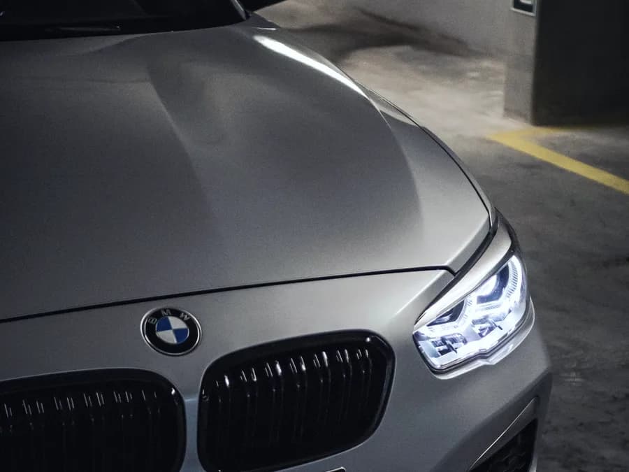 Frontal de un BMW Serie 1 gris mate en un aparcamiento cubierto